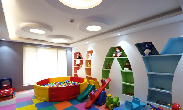 A vibrant and modern indoor children's play area with a colorful floor, ball pit, and toys, a key amenity for this family-friendly property for sale in Guwahati
