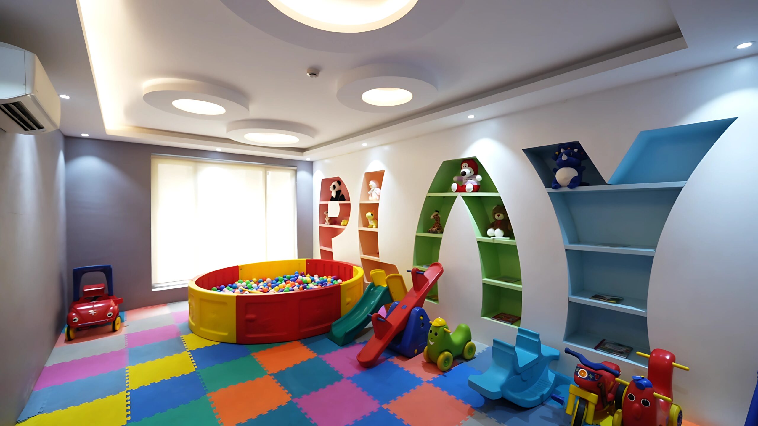 A vibrant and modern indoor children's play area with a colorful floor, ball pit, and toys, a key amenity for this family-friendly property for sale in Guwahati