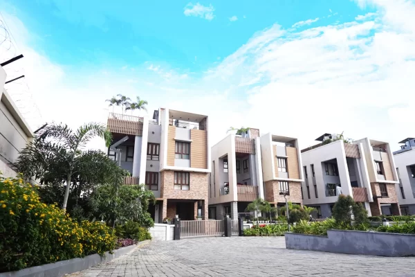 The secure, cobblestone entrance to a complex of modern, multi-story villas, highlighting a premium property for sale in Guwahati