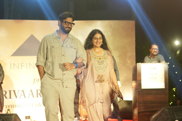 A couple walks on stage during the 'Parivaar Ke Sitaare' pre-Diwali event by Infinity Heights. This celebration highlights the elegant lifestyle offered at these luxury apartments in guwahati and apartments for sale guwahati.