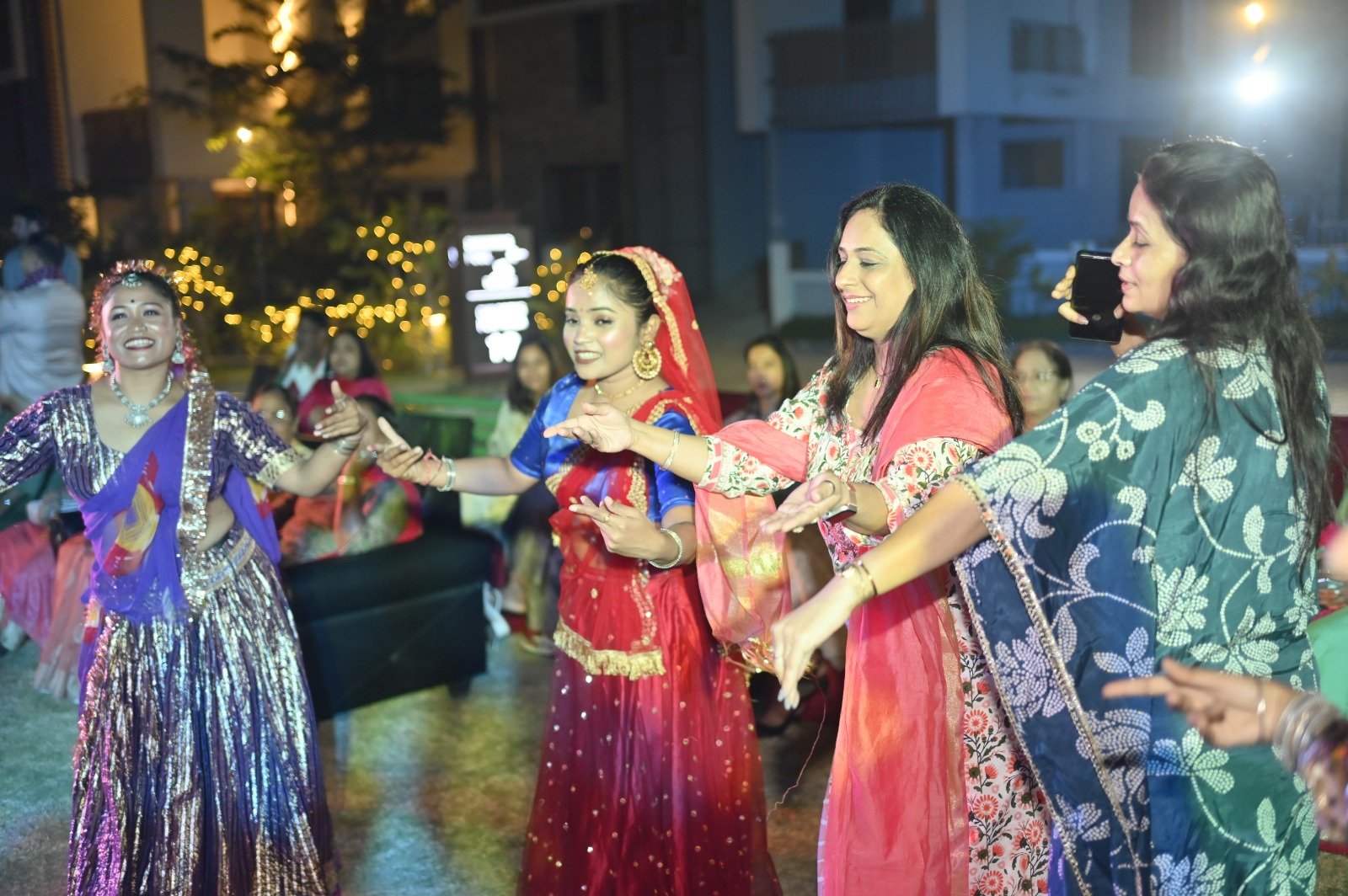 Vibrant 2026 Holi Dhamal at Infinity Heights Guwahati, featuring traditional dance and residents in ethnic wear near a luxury villa for sale in guwahati, celebrating community on the garden lawn.