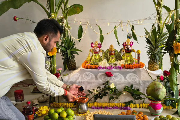 Resident offering prayers and lighting lamps at the deity altar inside an Apartment in Guwahati.