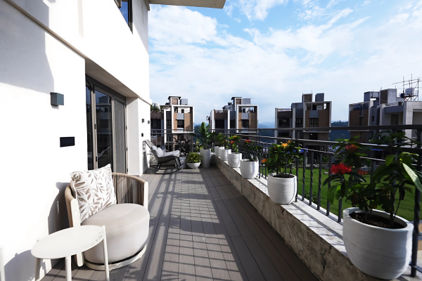 A spacious luxury apartment balcony featuring outdoor seating, potted plants along the railing, and scenic views of modern residential buildings under a bright blue sky.