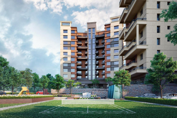 Architectural 3D rendering of Infinity Heights premium high-rise residential apartment complex in Guwahati, showcasing multi-story tower facades, a landscaped green lawn with an outdoor badminton court, and lifestyle amenities.