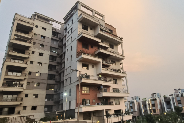 Modern multi-story apartment high-rise residential complex offering premium flat in Guwahati with expansive balconies under a dusk sky.