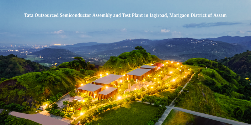 An overhead wide shot of the illuminated Tata semiconductor plant Assam facility in Jagiroad, Morigaon district, surrounded by lush green hills at twilight.