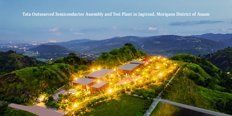 An overhead wide shot of the illuminated Tata semiconductor plant Assam facility in Jagiroad, Morigaon district, surrounded by lush green hills at twilight.