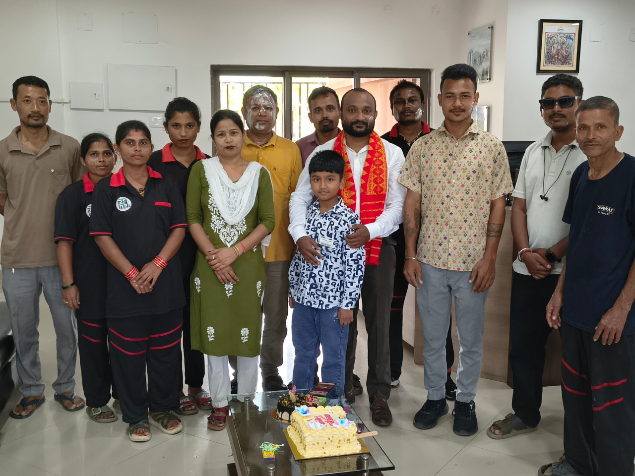 Residents and staff gathered indoors for an Independence Day cake-cutting celebration at Infinity Heights