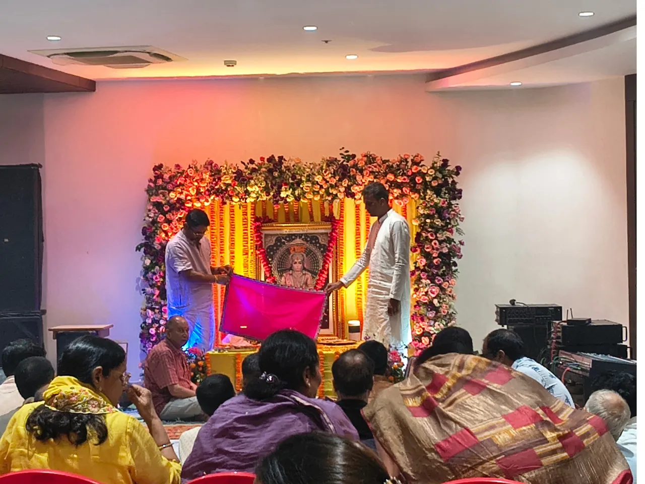 Residents and organizers conducting devotional prayer rituals during the community gathering at Infinity Heights apartment in Guwahati
