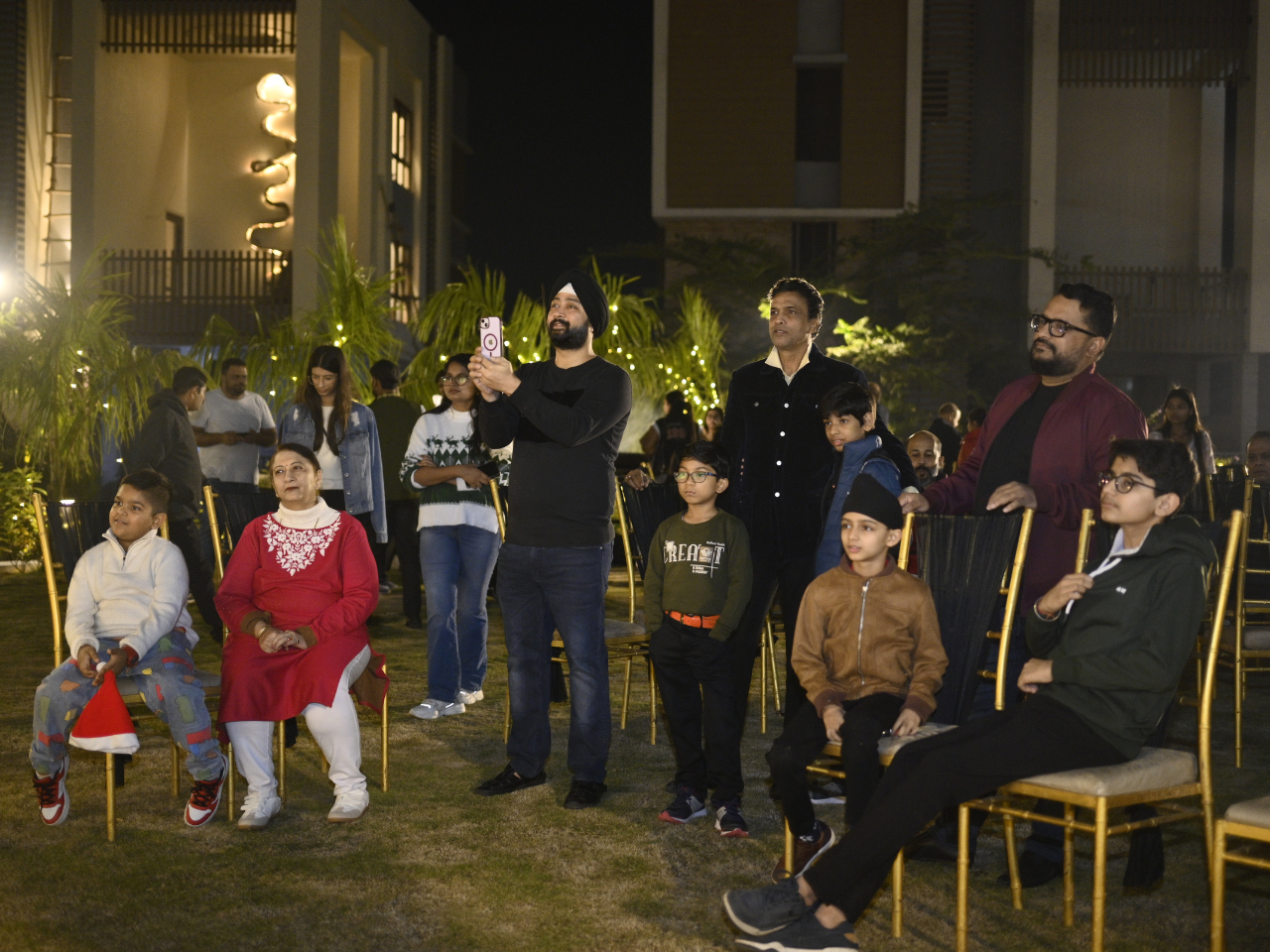 Families and children enjoying the outdoor evening Christmas festivities on the lawn at their apartment in Guwahati.