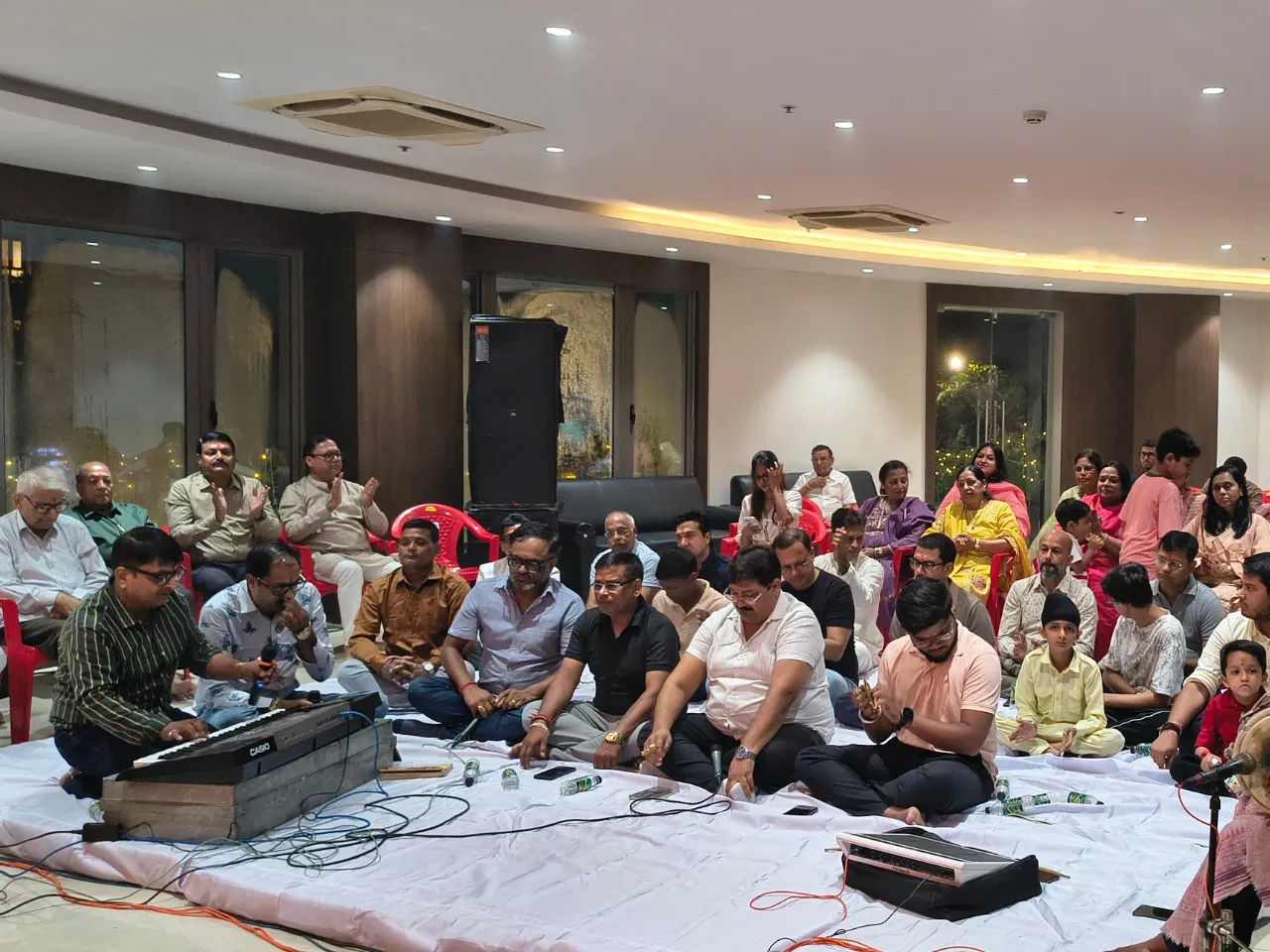 Community members enjoying live musical bhajans and kirtan at Infinity Heights residential apartment in Guwahati
