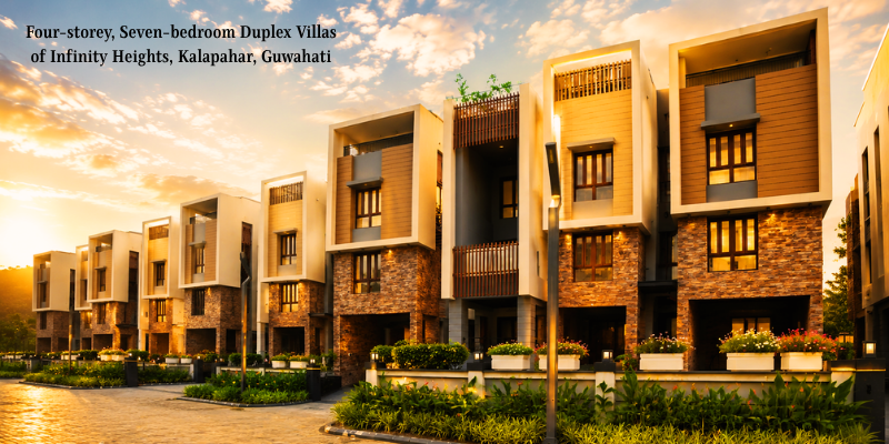 A row of modern four-storey duplex villas at Infinity Heights in Kalapahar, Guwahati, showcasing contemporary stone and wood-paneled facades illuminated by warm exterior lighting during golden hour.