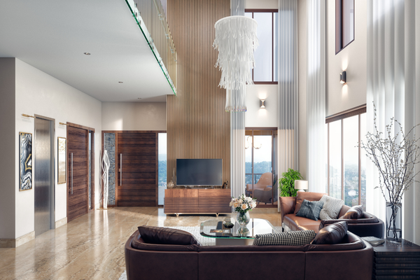 Double-height luxury formal living room featuring brown leather sofas, a high-ceiling wood-paneled TV wall, a white fringe chandelier, and expansive glass windows overlooking the city.