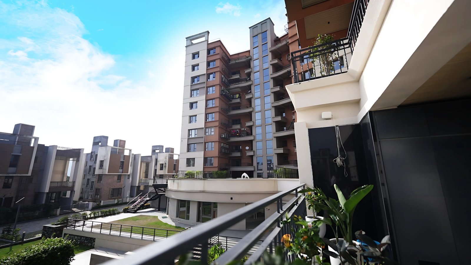 High-angle view from a private balcony overlooking the modern multi-storey residential towers and landscaped courtyard at Infinity Heights.