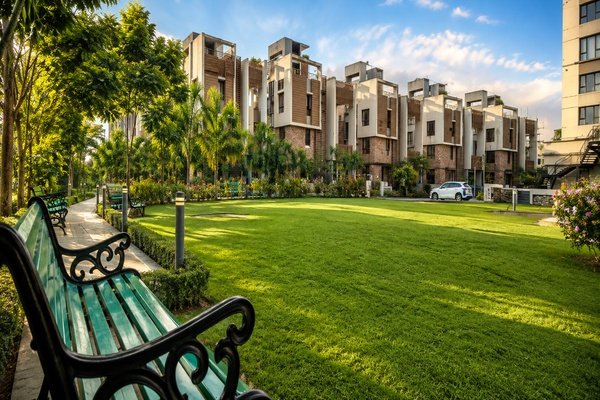 Lush green garden area with benches and senior living residences